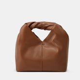 Bolsa marrom de design compacto com alça trançada integrada, confeccionada em material liso, ideal para um estilo moderno e minimalista.